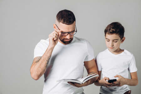 old and young generation . different interests. close up portrait. copy space. elder brother doing his little brothers homeworkの写真素材