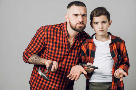 emotions. distrustful handsome bearded man and little boy looking at te camera. suspicious look. incredulous expressionの写真素材