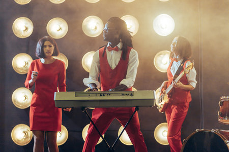 awesome afro guy playing the musical keyboard between two beusitiful women. music genre. classical...