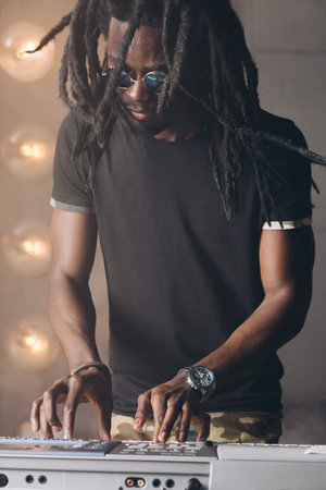 african man fixing the synthesizer. close up photo. man writing a music for song