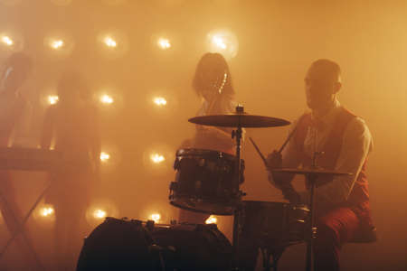 Drummer playing the drums during the concert.silhouette of man sitting near the drum . performance , hobby, lifestyleの写真素材