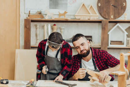 In carpentry coworking studio children and youngsters can learn a useful profession together with Dad. There are carpentry classes for beginners in the Daddy-son format in wooden workshop.の写真素材