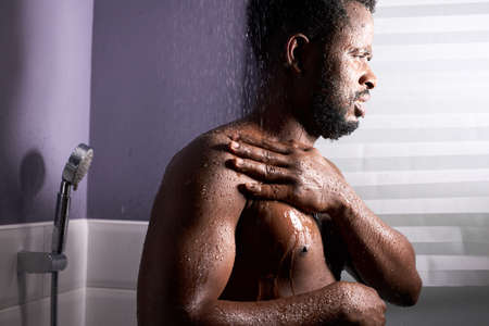middle aged man in shower cubicle, taking a shower alone.の写真素材