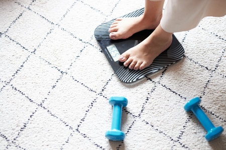 female feet being weighed on a scale at home, healthy lifestyle, weight loss, sport concept