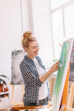 happy nice lovely girl cleans off unnecessary paint. close up side view photo.fine art conceptの写真素材