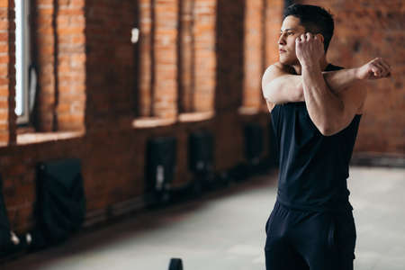 Fitness man with ideal body doing exercises at the Gym.athlete warming up during training. copy space. close up. man doing morning exercise indoorsの写真素材