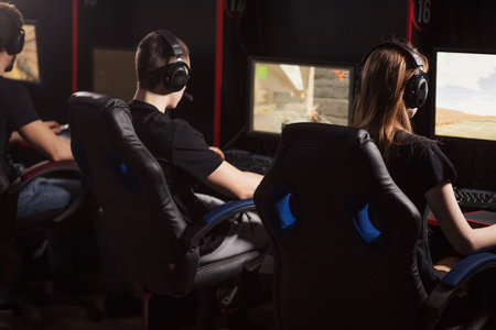 Professional Gamers participating in online cyber games tournament, sitting at pc gaming club or in...