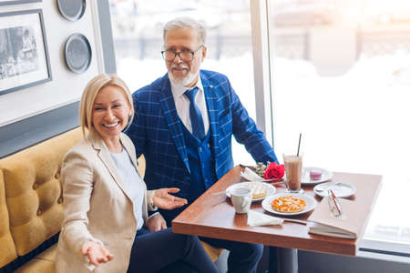 Mature happy couple celebrating an event and looking at the camera at cafe. close up photo. family celebrating wedding dayの写真素材