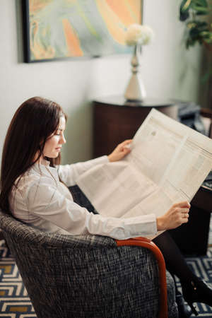 Woman reading newspaper background.の写真素材