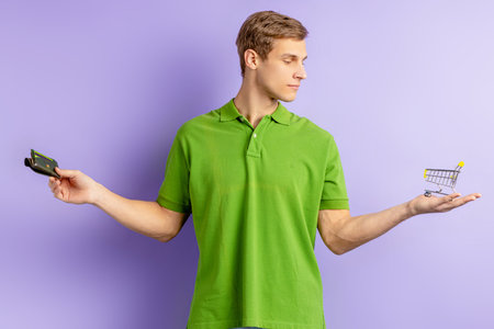 young caucasian man holding toy truck in one hand and wallet in other.
