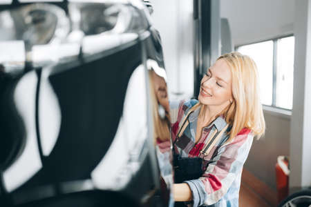 Woman changing car wheel background.の写真素材