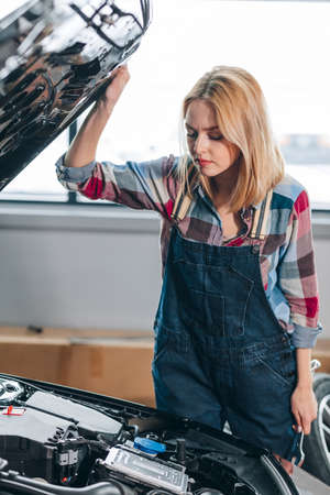 Woman opening the hood of the car at the garage.の写真素材
