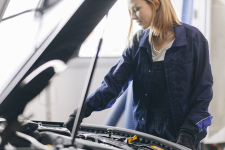 close up photo. cute female master checking the engine on vehicle.