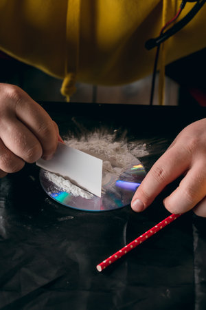 Drug abuse concept., hipster snorting lines of cocaine powder. close up cropped photo.