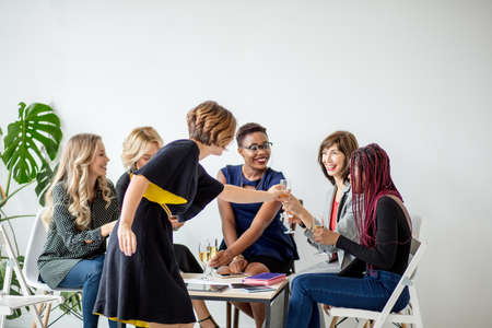 Multiracial Group of mid-aged women toasting with champagne, giving thanks to the Womens Seminar for the views that have been submitted to the Conference for its consideration.の写真素材