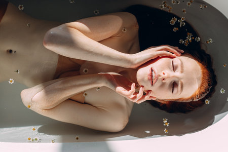 Young pretty redhead woman with coopery hair taking bath. Sensual sexy female model relaxing in a...