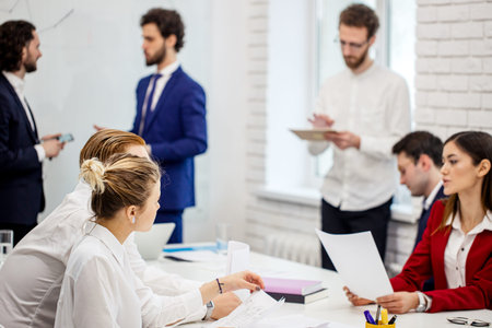 group of young caucasian business leaders gathered in office to discuss projects and ideas together,...