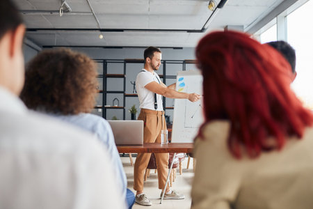 Ambitious young caucasian coach leader give presentation to co-workers sitting listening to him in...