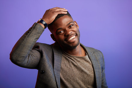 Portrait of smiling dark-skinned man in smart casual jacket and t-shirt, having fun and joy smiling...