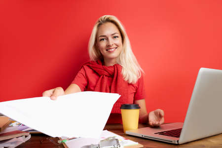 positive boss hold interview at work, give application, smile at camera isolated over red backgroundの写真素材