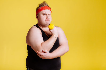 Fat man lifting dumbbell and show his bicepsの写真素材