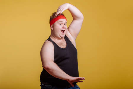 Happy fat man makes kung-fu exercise, rise hands, crane poseの写真素材