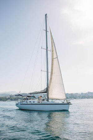 Sailing ship yacht with white sail in the open sea heading to neapolis coast