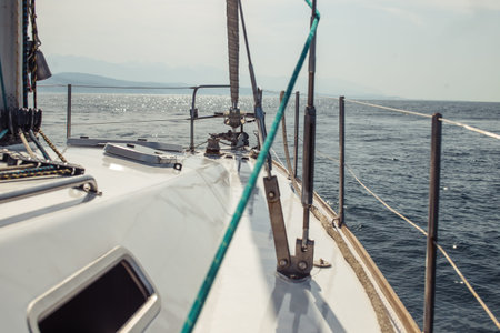 Deck of a white yacht close up during the ocean voyage in daylight over calm sea water background