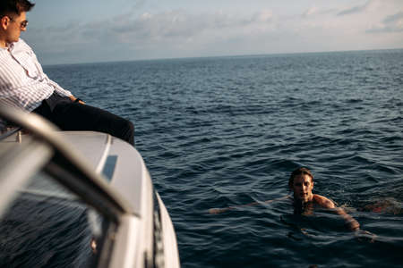 Bathing at open sea space. Young man bathing and swimming during sea excursion to islands, in hope to see dolphins or sea turtlesの写真素材