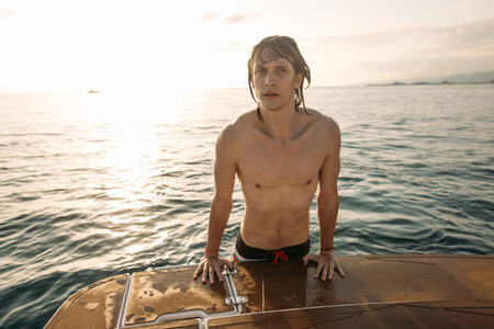 Caucasian man traveler floating on motorboat along sea coast with hotels and urban scape. Summer...