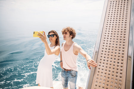 Happy caucasian couple in love taking selfie on sailing boat, relaxing on a yacht. Loving couple at...