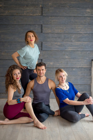 Fit sporty happy caucasian people posing before yoga training, concept of team support in fitness...