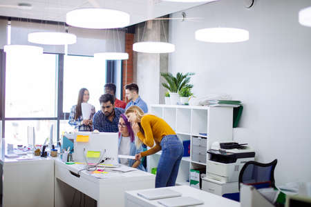 startup business multiethnic team discussing new business plan in modern bright office interior brainstorming, working on laptop and tablet computerの写真素材
