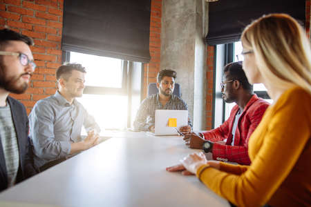 Successful start depends on good fresh idea and discipline. Young multi ethnic partners wearing casual bright clothes, discussing ideas for new strategy of development at modern loft office.の写真素材