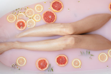 No face caucasian woman taking a bath. Close up of perfect female bottom, hips and legs with citrus...