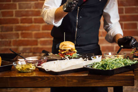 Master class of professional Chef making high quality burgers. Ready fresh green burger on wooden tableの写真素材