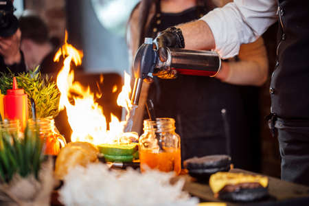 Chef making beef burgers indoor at restaurant kitchen, participating in food festival event.の写真素材
