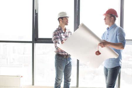 strict angry boss isnt satisfied with his engineers work. side view photo. irritation, dissatisfaction conceptの写真素材