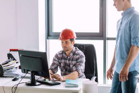 serious handsome engineer is working with computer indoors. computer engineering conceptの写真素材