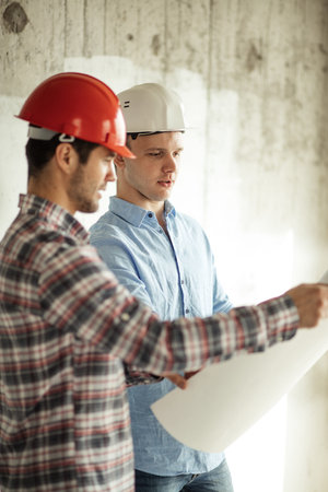 new employeer in white helmet and blue shirt is learning the duties of engineers at work.side view...