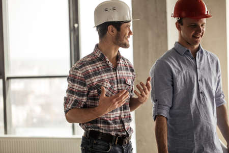 active positive engineers are having fun at workplace. positive workers in hardhatsの写真素材