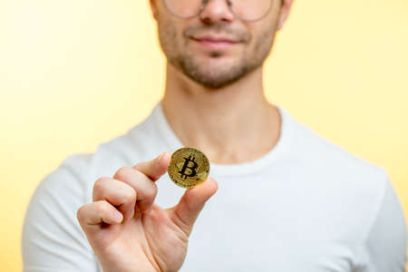 close up cropped photo of a coin which is hold by a bearded man. saving conceptの写真素材