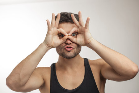 funny man is looking through glasses from fingers