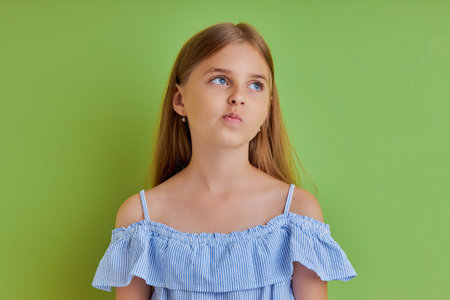 portrait of caucasian nice-looking attractive pretty pre-teen girl creating solution isolated over...