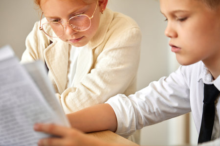 friendly kids couple behave themselves as adults, solve work problems together, look at laptop and...