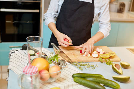 close up cropped photo. female is going to put apples in the bowl in the kitchen roomの写真素材