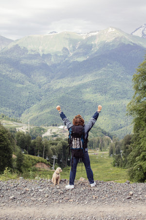 adventurous guy is celebrating the climbing to the peak.back view full length photo. luck, tourism,...