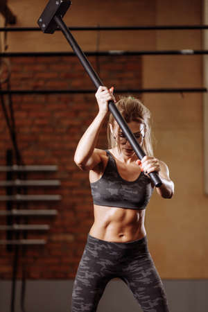 free time.young pleasant woman in glasses is strengthening the muscles of arms. close up photo.の写真素材