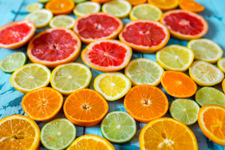Abstract background of citrus slices. Close-up of fresh orange, tangerine, grapefruit, lime and lemon slices on blue background, citrus slice texture.の写真素材