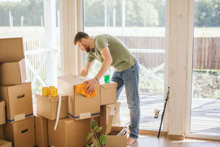 Smiling couple hold boxes in new home. Dreaming new homeの写真素材
